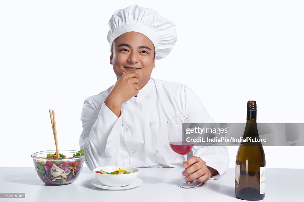 Chef with glass of wine thinking