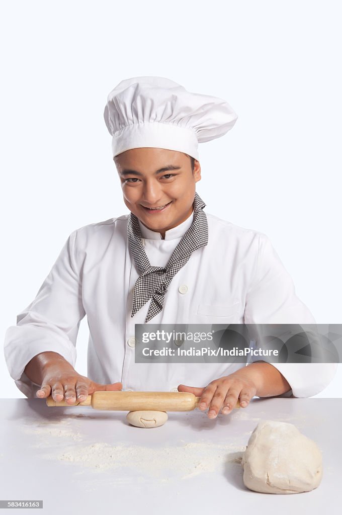 Portrait of chef rolling dough