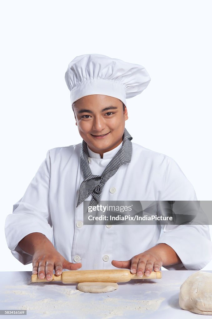 Portrait of chef rolling dough