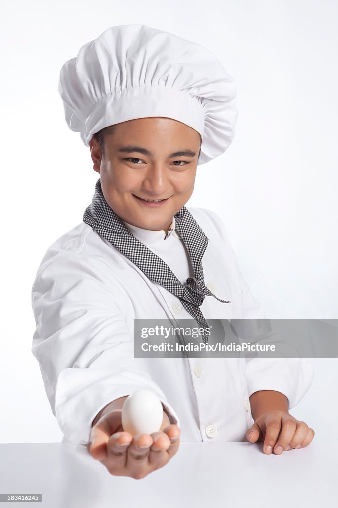 Portrait of chef with egg