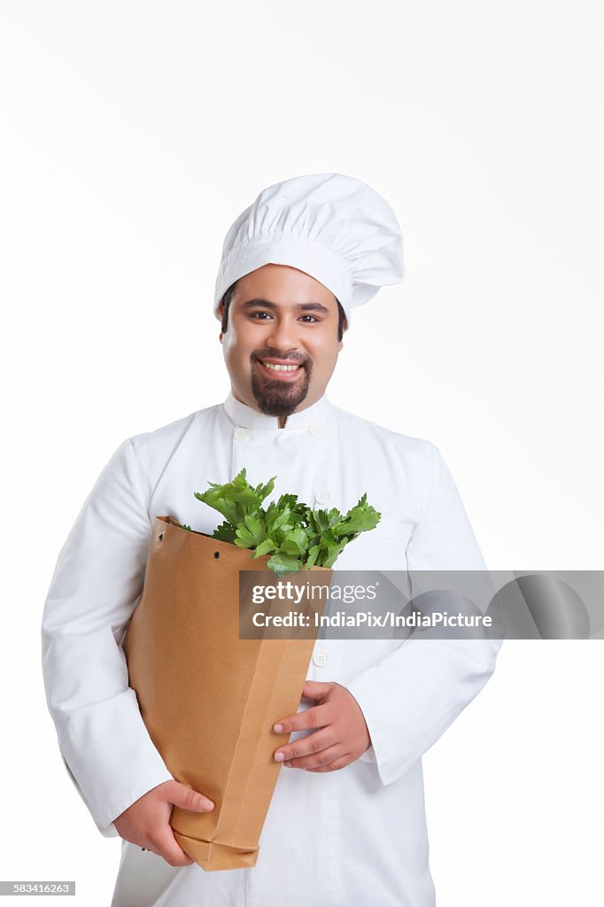 Portrait of chef with bag of vegetables