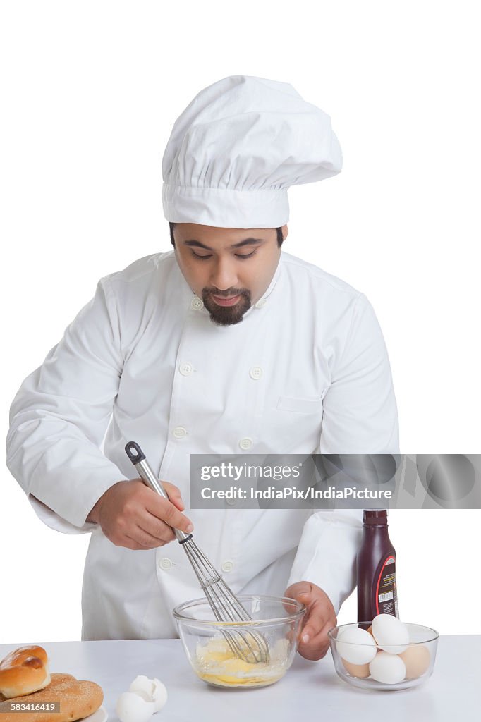 Chef mixing egg in bowl