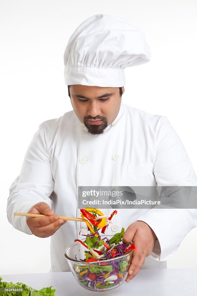 Chef looking at vegetables in bowl