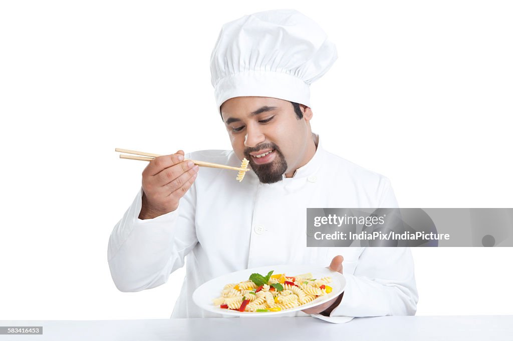 Chef eating pasta with chopsticks