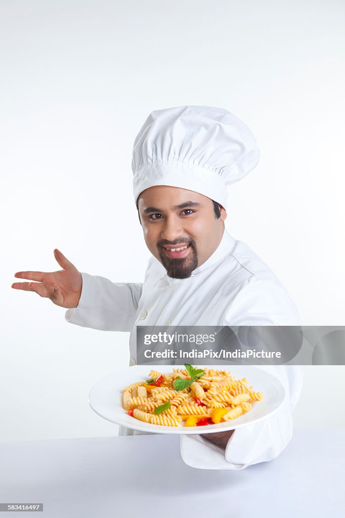 Portrait of chef with plate of pasta