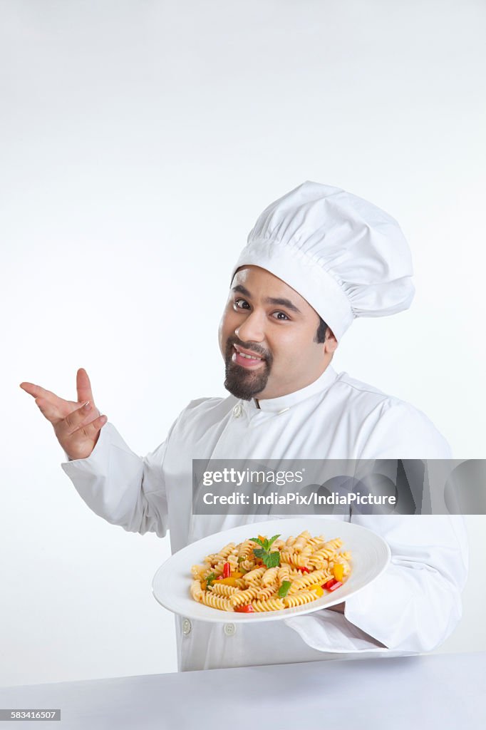 Portrait of chef with plate of pasta