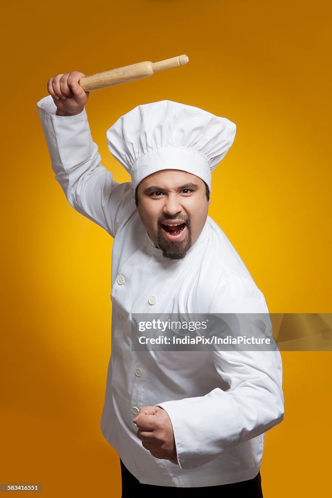 Portrait of angry chef with rolling pin