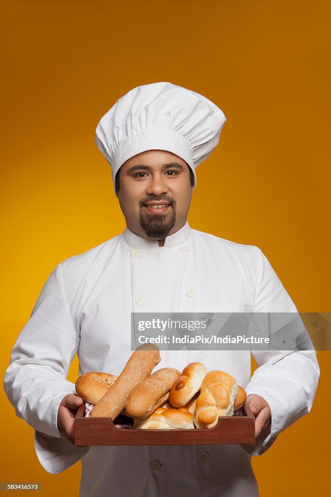 Portrait of chef with tray of bread