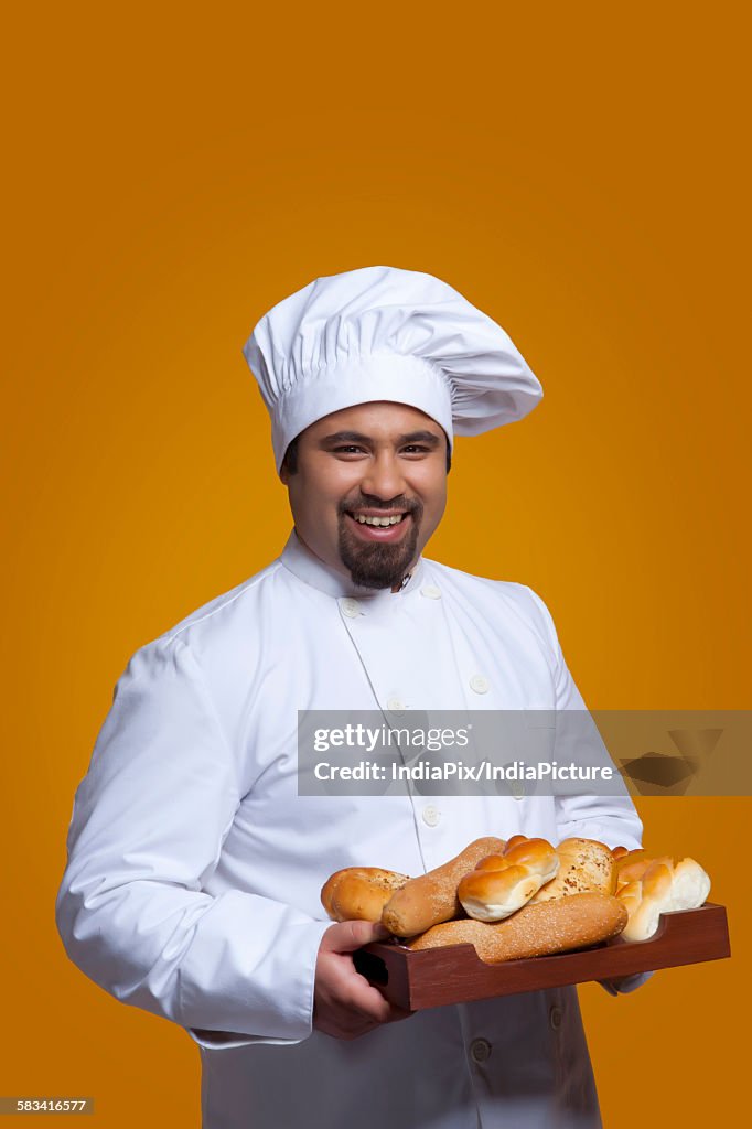 Portrait of chef with tray of bread