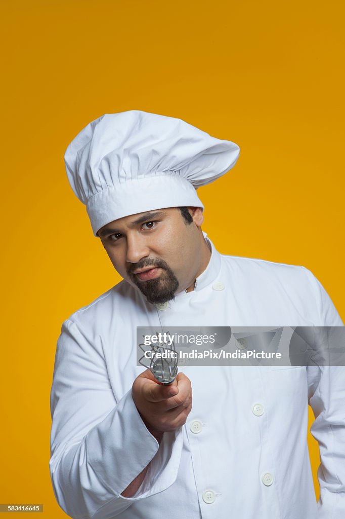 Portrait of chef holding wire whisk