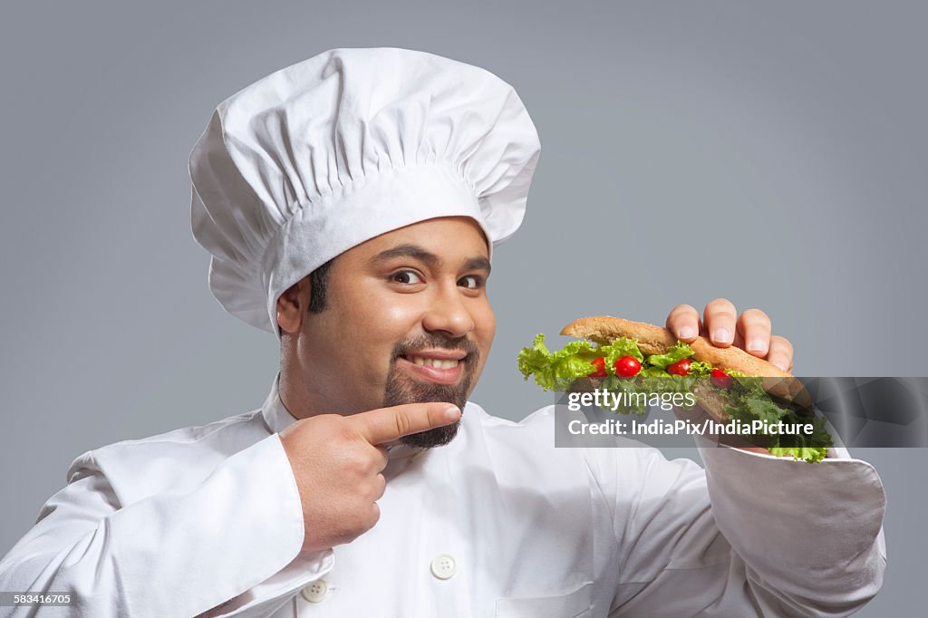 Portrait of chef pointing at sandwich