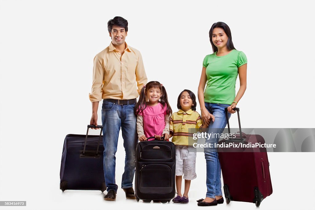 Portrait of family with suitcases