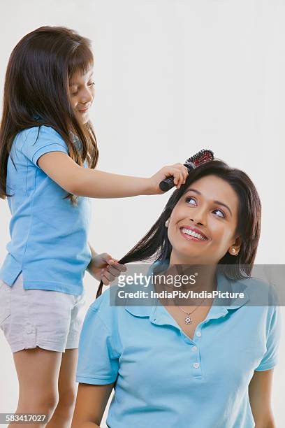 girl brushing mothers hair - rolwisseling stockfoto's en -beelden