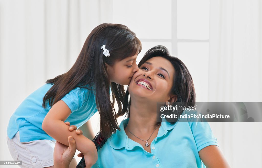 Girl kissing mother on cheek