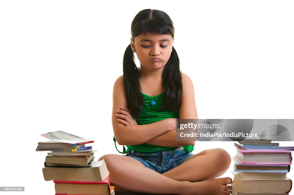 Girl sitting with a pile of books