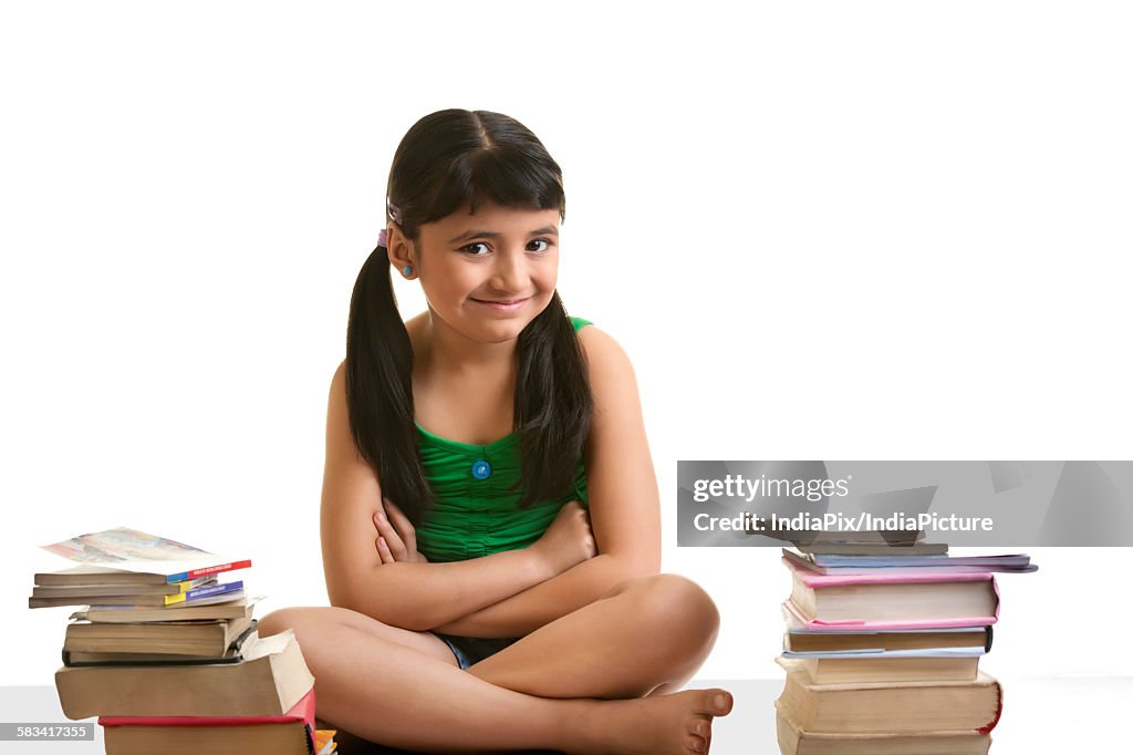 Girl sitting with a pile of books