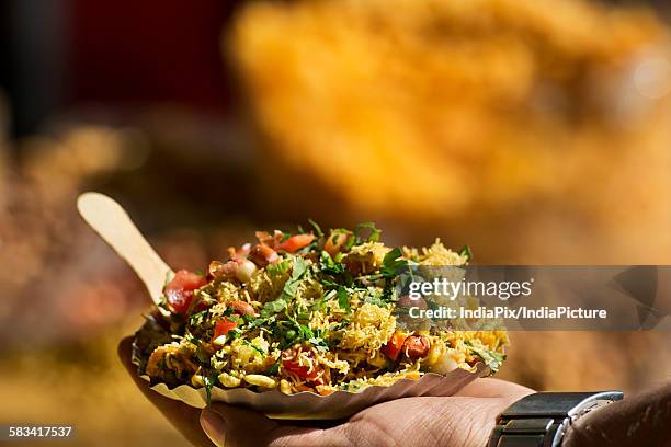 man holding bhelpuri plate - puffed rice stock pictures, royalty-free photos & images