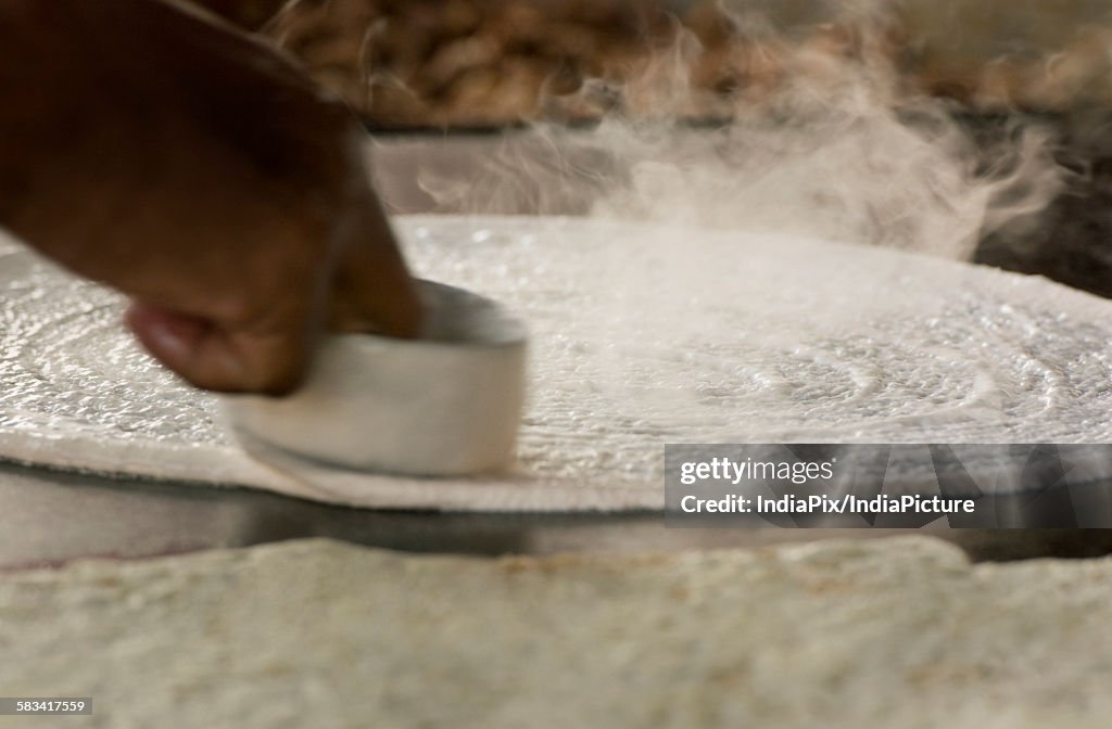 Dosa batter being spread on tawa