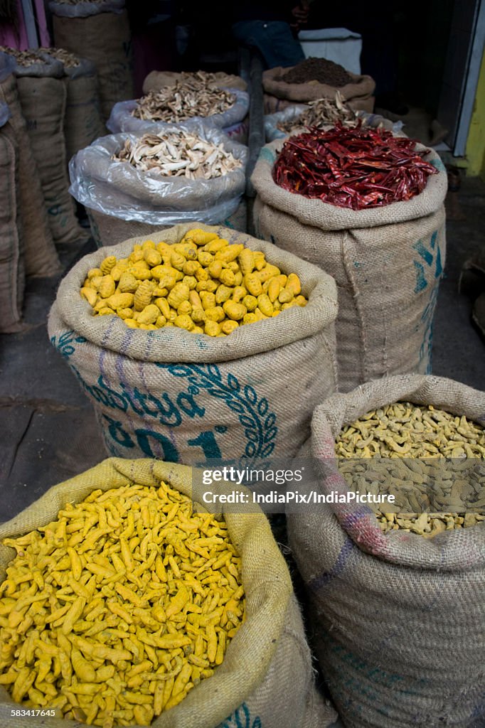 Sacks of dried chillies and turmeric root for sale at the market