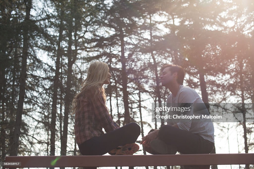 Young couple sit on bench in woods