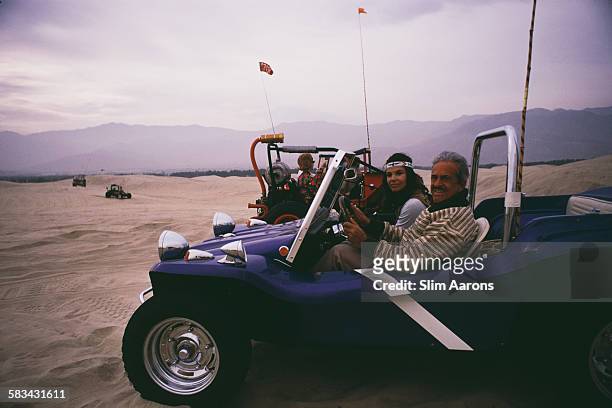 French-born American industrial designer Raymond Loewy and his second wife, Viola, with their dune buggy in the desert near Palm Springs, California,...