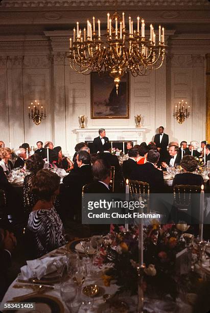Wide view showing guests and the interior during a White House reception for German Chancellor Helmut Schmidt, visible in the center distance,...