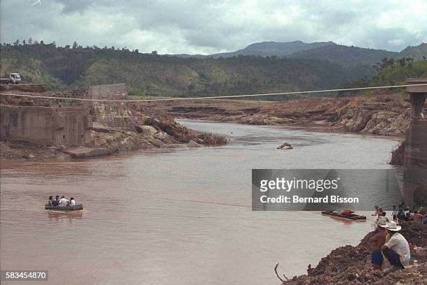 Following the destruction of a bridge over the Horo Agua, makeshift boats are used to cross over