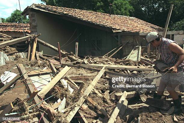 Survivor trying to salvage belongings from what remains of her house.