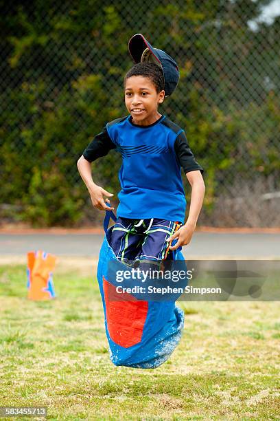 boy leaping in school sack race - sack race stock pictures, royalty-free photos & images