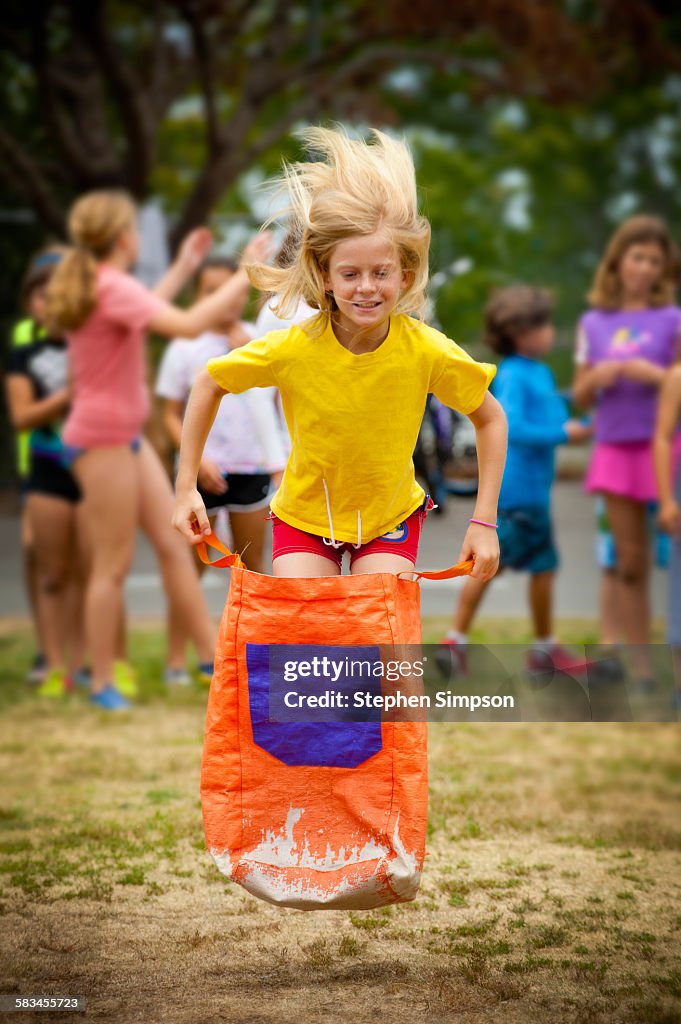 Girl leaping on school sack race