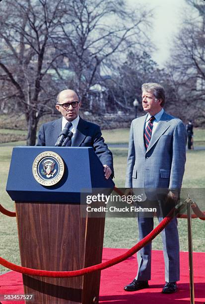 United States President Jimmy Carter stands behind Israeli Prime Minister Menachem Begin, while Begin addresses the press after a round of...