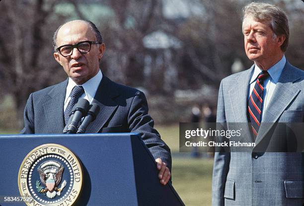 United States President Jimmy Carter stands behind Israeli Prime Minister Menachem Begin, while Begin addresses the press after a round of...