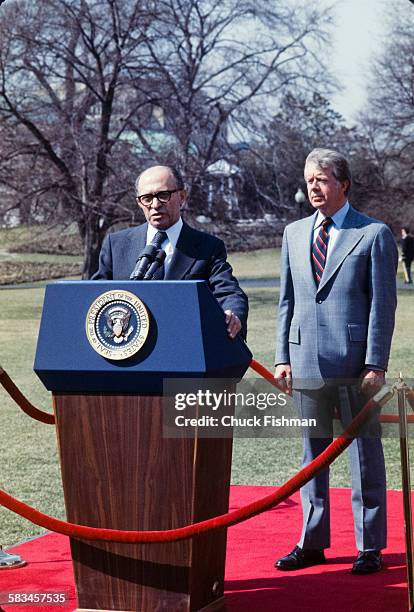 United States President Jimmy Carter stands behind Israeli Prime Minister Menachem Begin, while Begin addresses the press after a round of...