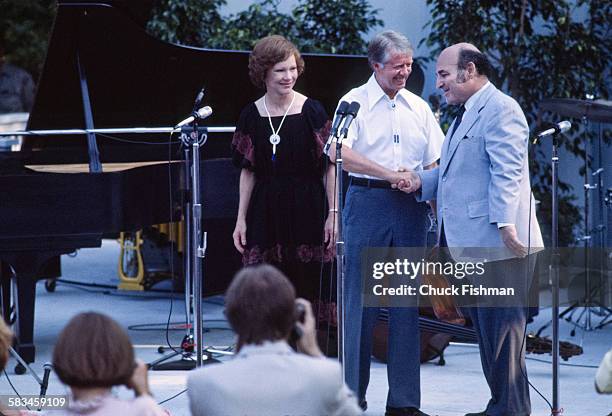 President Jimmy Carter, center, shakes hands with jazz festival producer George Wein at a White House Jazz Concert on the south lawn on the occasion...