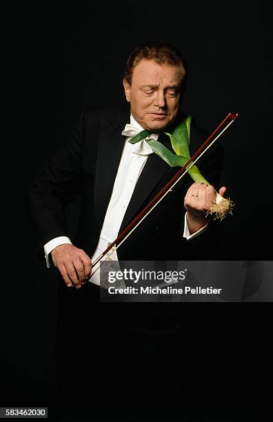 French television presenter Jacques Martin holds a leek and a bow as if he were playing viola.
