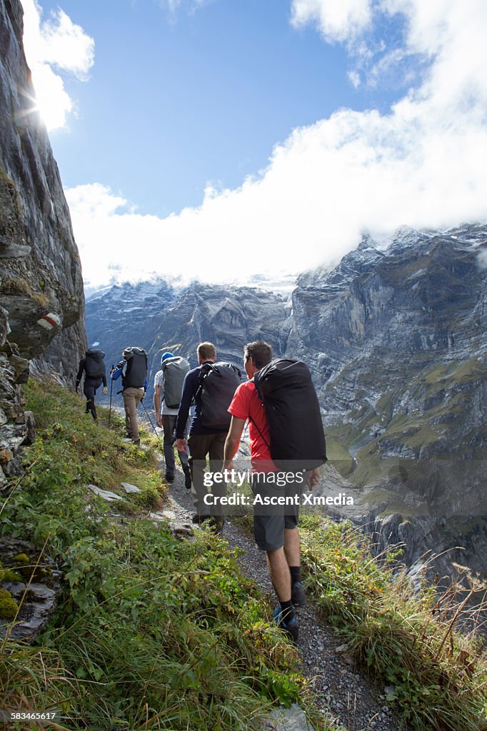 Wingsuit fliers hike up mountain trail, to launch