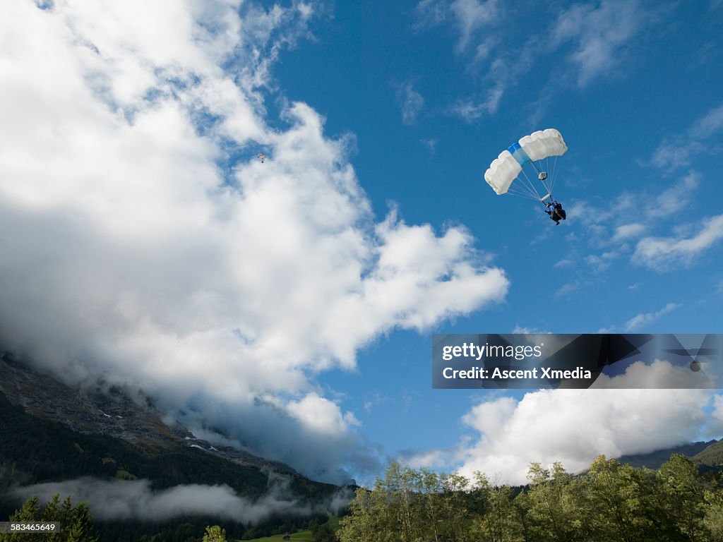 Wingsuit flier in final descent over mountains