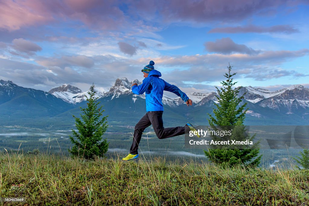 Cross country runner traverses grassy mountainside
