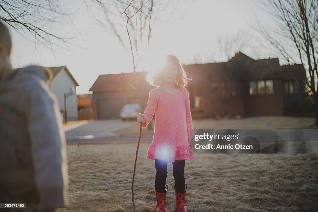 Girl Holding a Large Stick