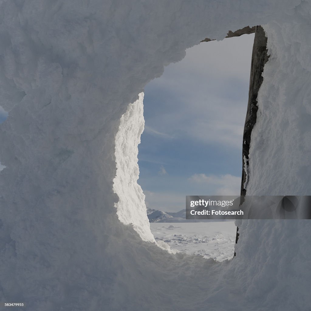 Snow covered mountains viewed through a snow covered inuksuk