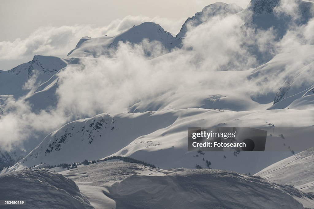 Clouds over snowcapped mountains