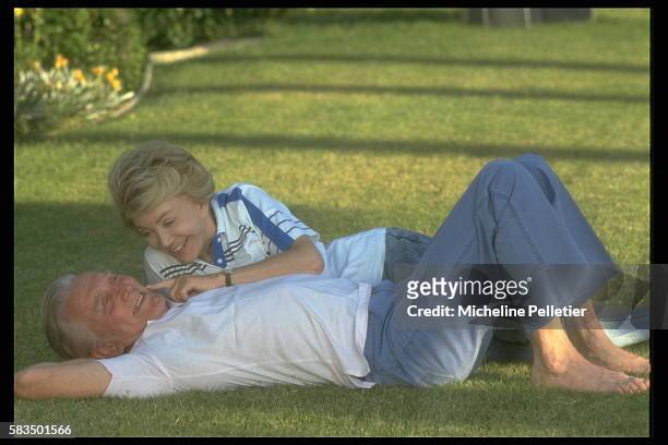 American actor, Kirk Douglas, relaxes on his lawn, with his wife, Anne.
