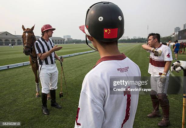 John Fisher, Director of Stable Operations, left, speaks with Chinese players Quan Zehao, right, and Dai Zihan from the Metropolitan Polo Club team...