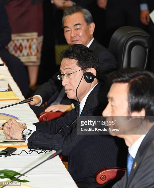 Chinese Foreign Minister Wang Yi, Japanese Foreign Minister Fumio Kishida and South Korean Foreign Minister Yun Byung Se attend a meeting with their...