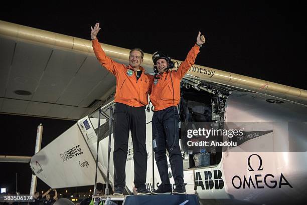 Solar Impulse 2 pilots Bertrand Piccard and Andre Borschberg waves to the crowd after landing in Abu Dhabi to finish the first around the world...