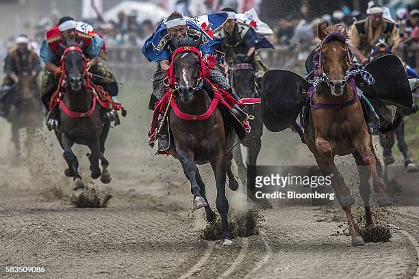 Samurai horsemen compete in the Yoinori Keiba race during the Soma Nomaoi festival at Hibarigahara field in Minamisoma, Fukushima Prefecture, Japan,...