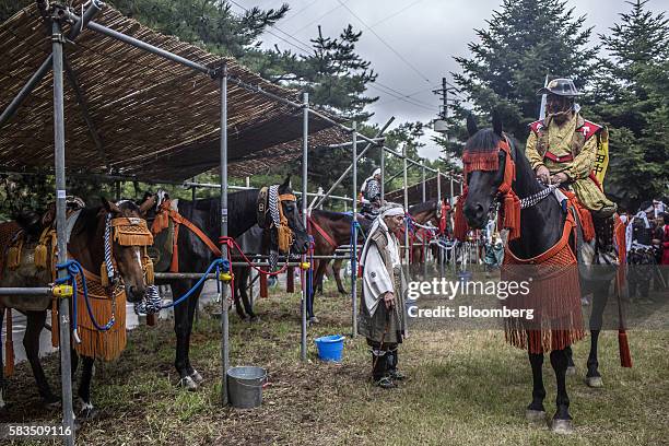 Samurai horseman prepares to dismount after the Soma Nomaoi festival in Minamisoma, Fukushima Prefecture, Japan, on Sunday, July 24, 2016. Every...