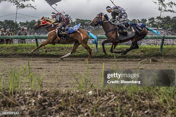 Samurai horsemen compete in the Kachu Keiba race during the Soma Nomaoi festival at Hibarigahara field in Minamisoma, Fukushima Prefecture, Japan, on...