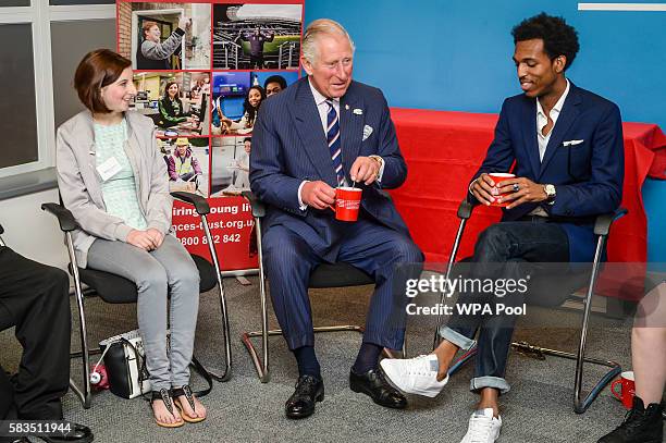 Prince Charles, Prince of Wales laughs as he is given a cup of tea with two spoons in it by mistake during a visit to his his Prince's Trust centre...
