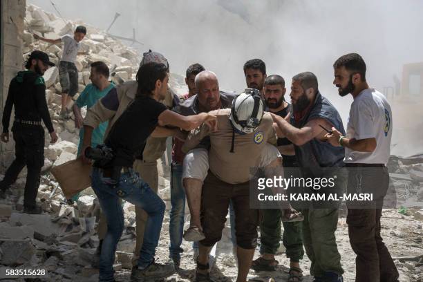 Syrians carry a wounded man away from the rubble of a building that according to the Syrian Observatory for Human Rights was destroyed during a...